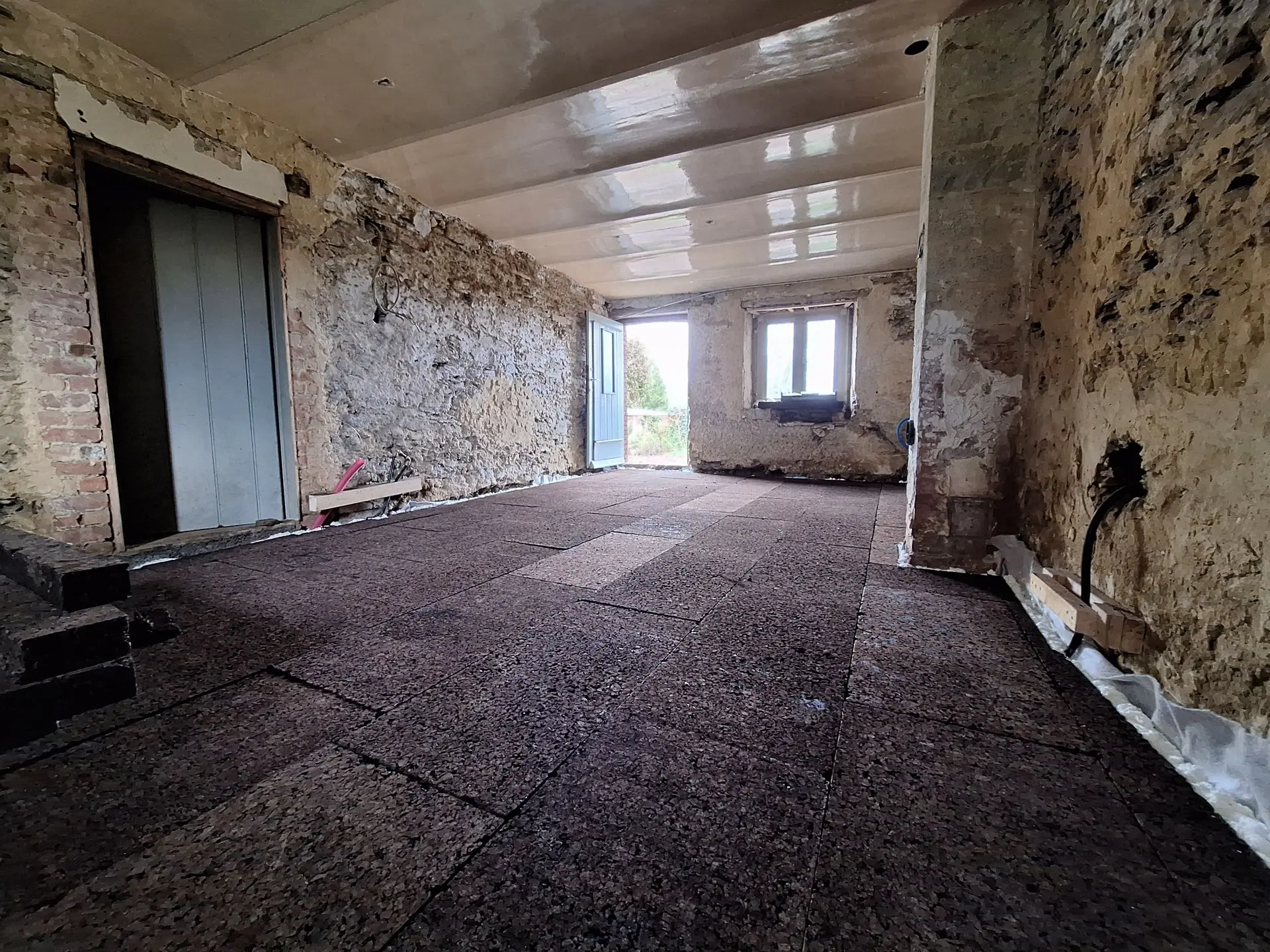Isolation du sol en liège expansé – Confort et performance naturelle. Pose de panneaux de liège pour l’isolation thermique d’un sol dans une maison en pierre à Manhay (Belgique). Solution naturelle et performante contre les pertes de chaleur